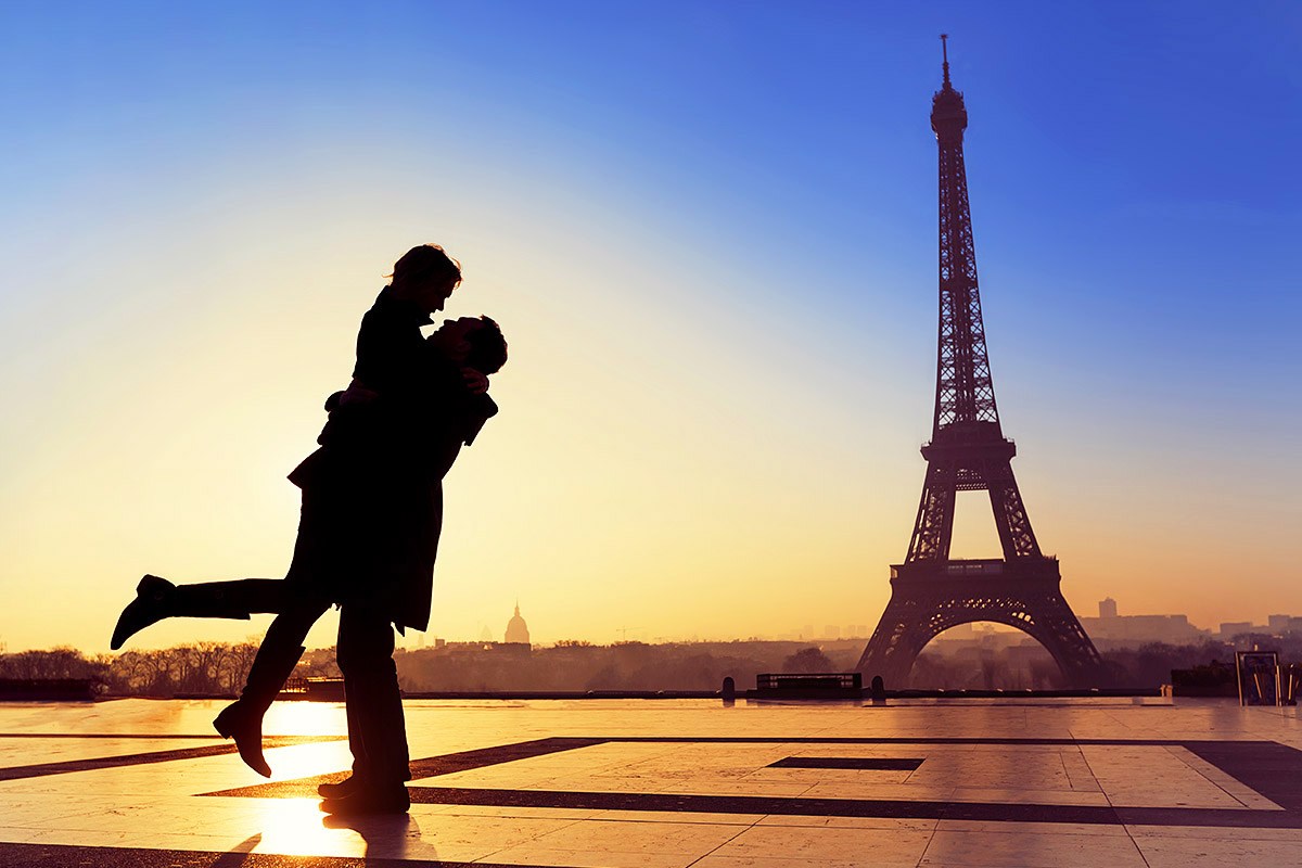 Loving couple kisses on a Eiffel Tower background Loving couple kisses on a Eiffel Tower background