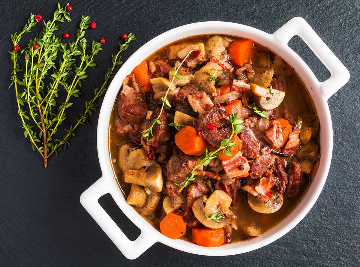 Image of a plate with baked beef, bacon, garlic, carrots, onions, mushrooms Image of a plate with baked beef, bacon, garlic, carrots, onions, mushrooms