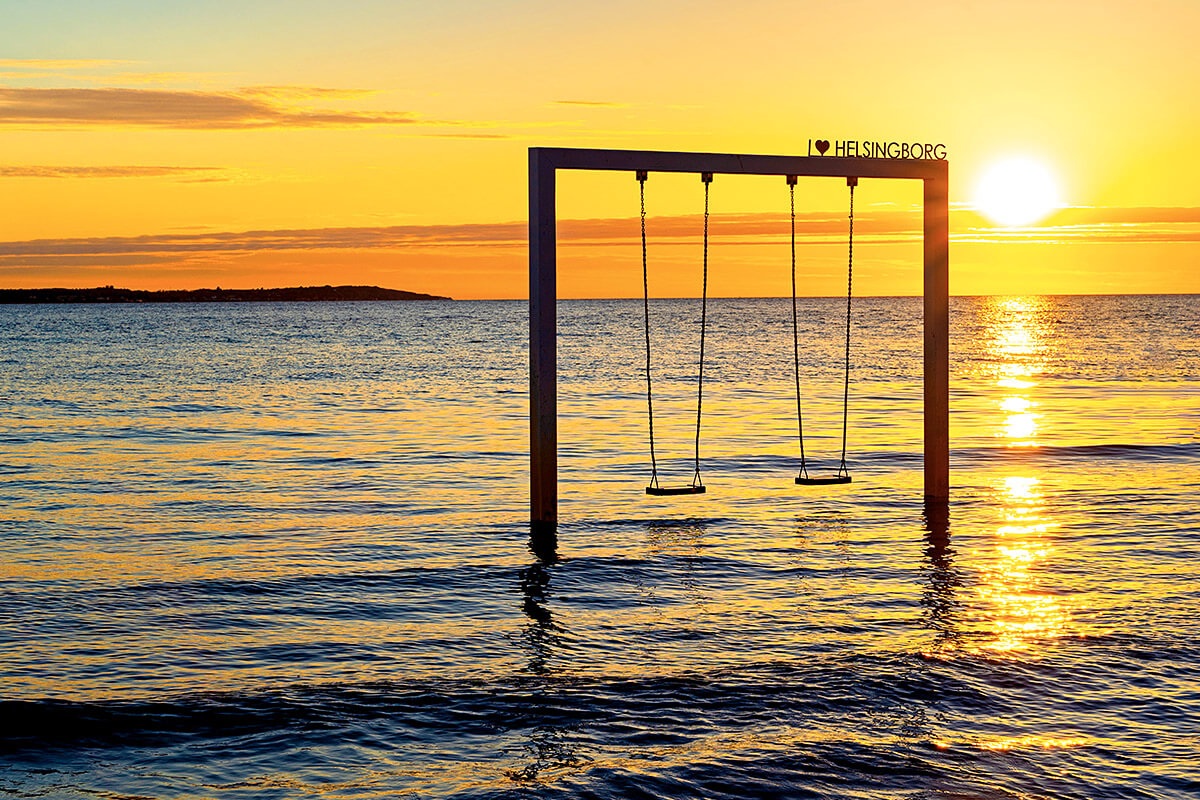 Image of a beach swing in the water at sunset, city of Helsingborg