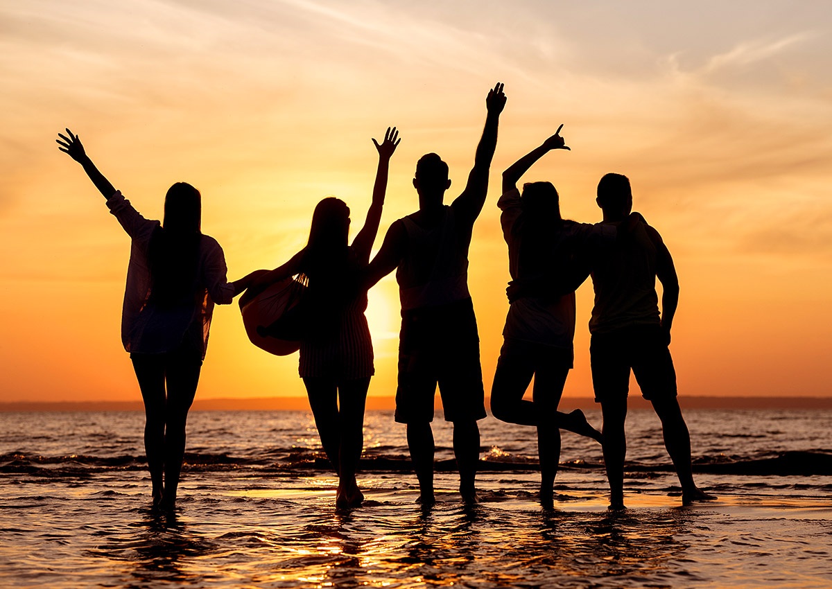 Cheerful group of young people stands in the sea, Ibiza Island, Spain
