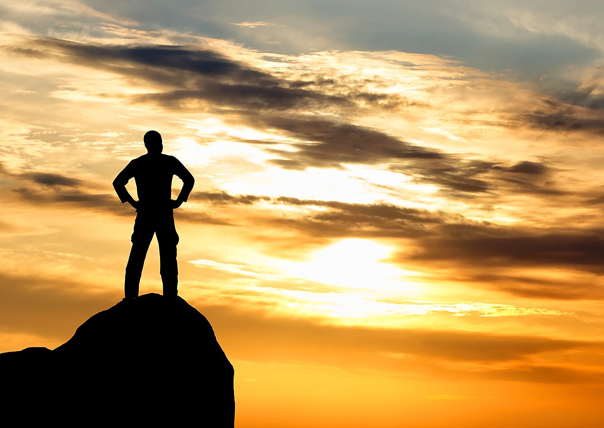 Image of a man standing on a mountain at the time of sunset