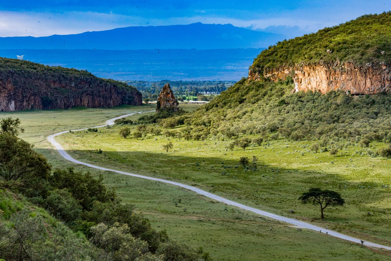 A spectacular panoramic landscape photograph capturing a dramatic river valley carved through towering rocky escarpments.