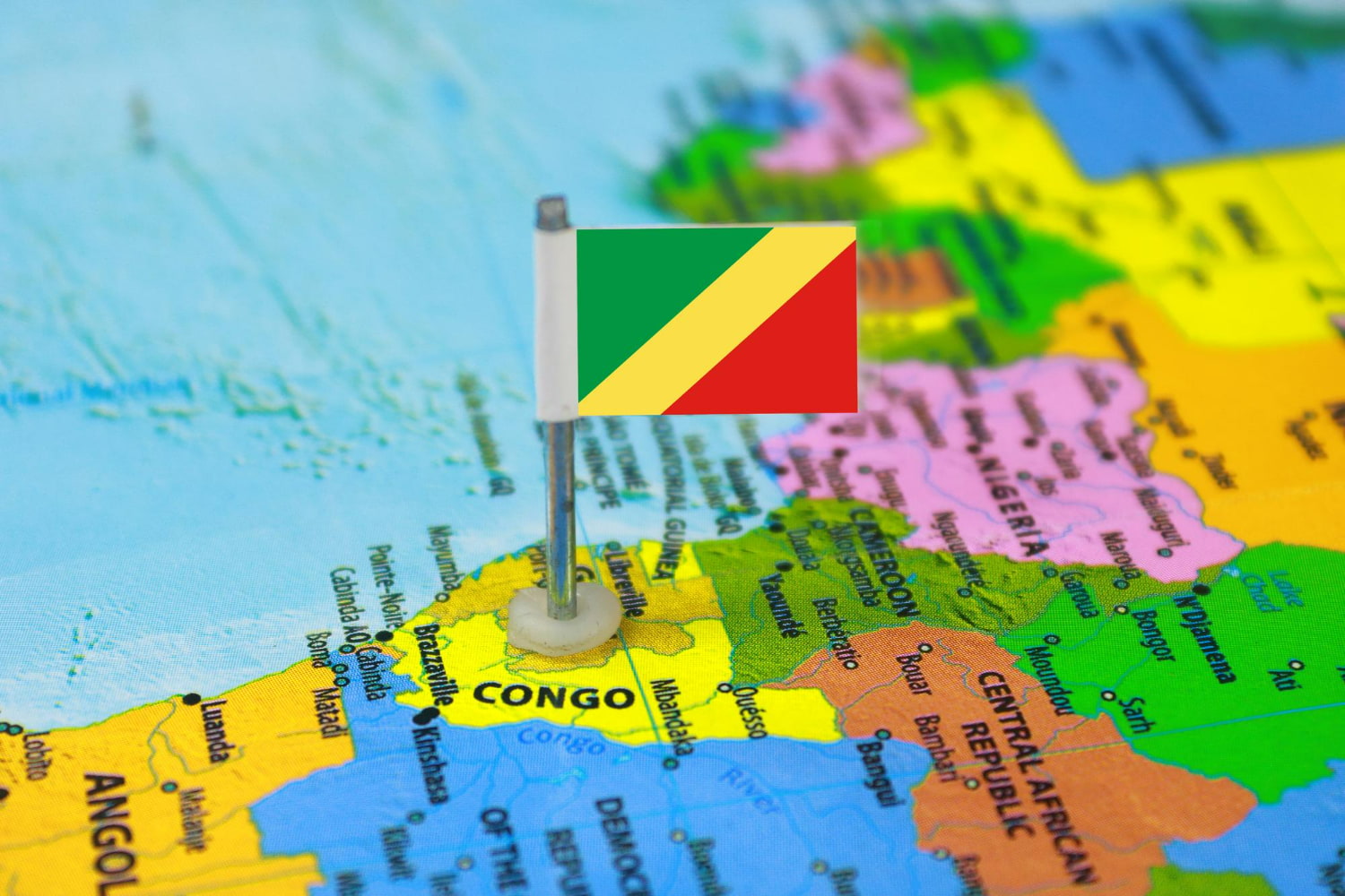 This symbolic photograph captures a miniature flag of the Republic of the Congo positioned proudly on a colorful political map of Africa.
