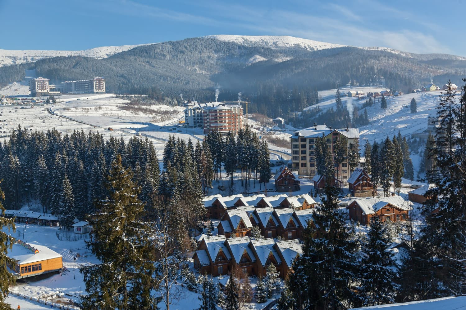 This breathtaking aerial photograph showcases a sprawling mountain resort nestled in a snow-covered.