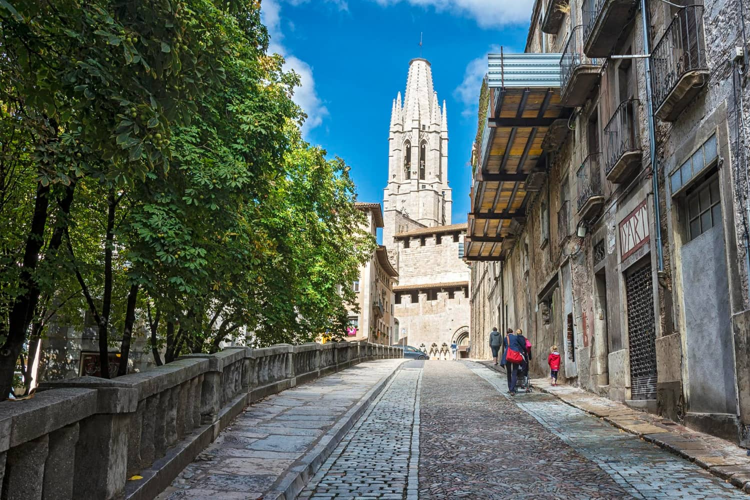The narrow street is lined with ancient stone buildings on both sides, their weathered facades telling stories of centuries past.