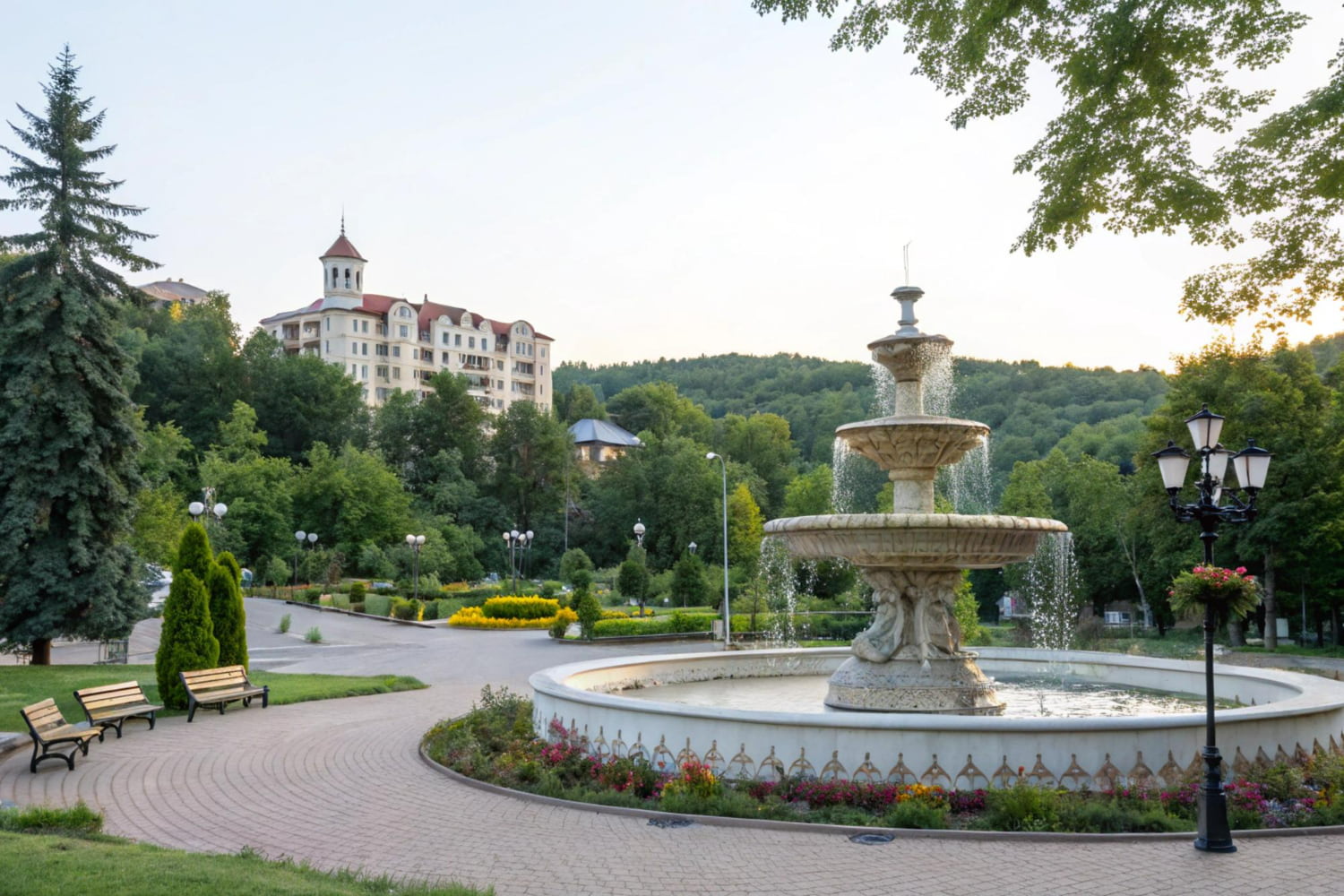 The backdrop showcases a striking historic building with traditional red-tiled roofs and a prominent bell tower, nestled within forested hills.