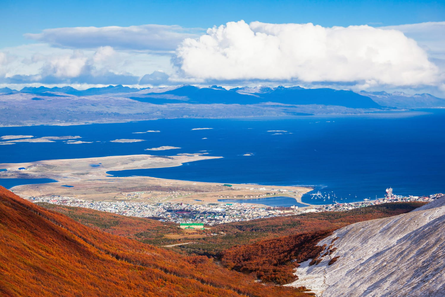 This breathtaking aerial photograph captures Ushuaia from an elevated vantage point—likely from the slopes of the Martial Mountains.