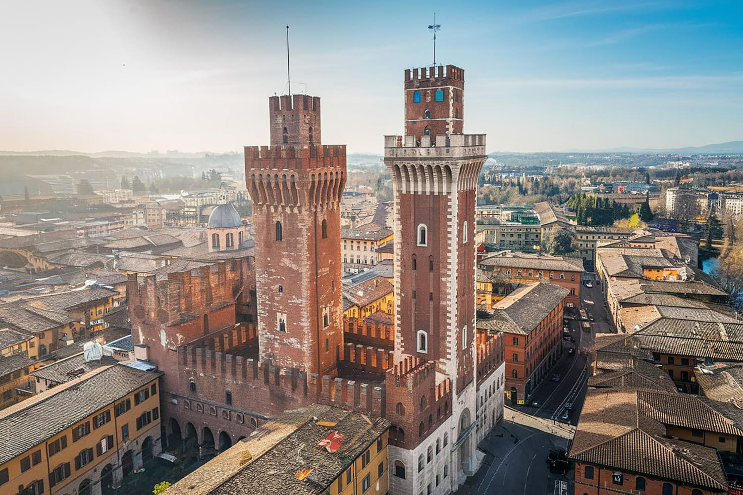 This stunning aerial photograph showcases the iconic medieval towers that define Volterra, one of Tuscany's most dramatically positioned ancient cities.