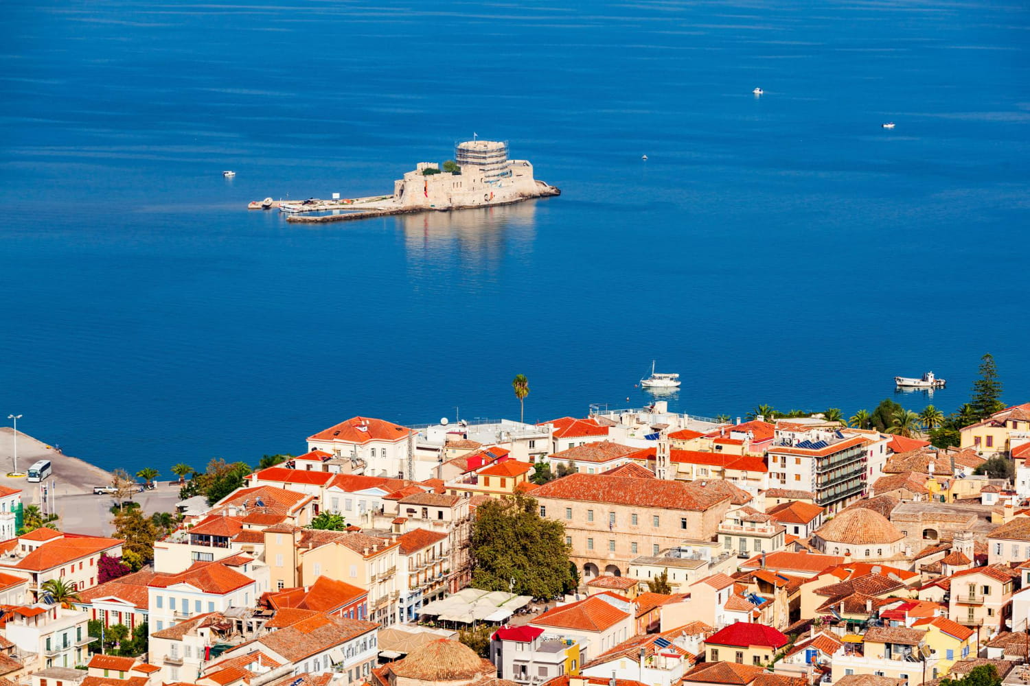 This spectacular aerial photograph captures the postcard-perfect beauty of a traditional Mediterranean coastal town perched above crystalline turquoise waters.
